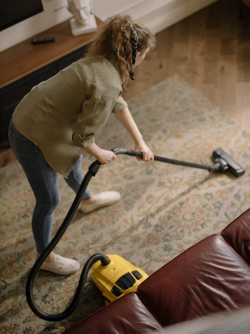 woman in long sleeve shirt holding a vacuum cleaner